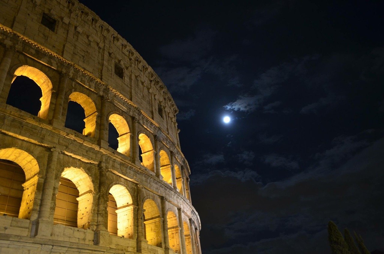 le colisée de rome la nuit avec le lune en fond